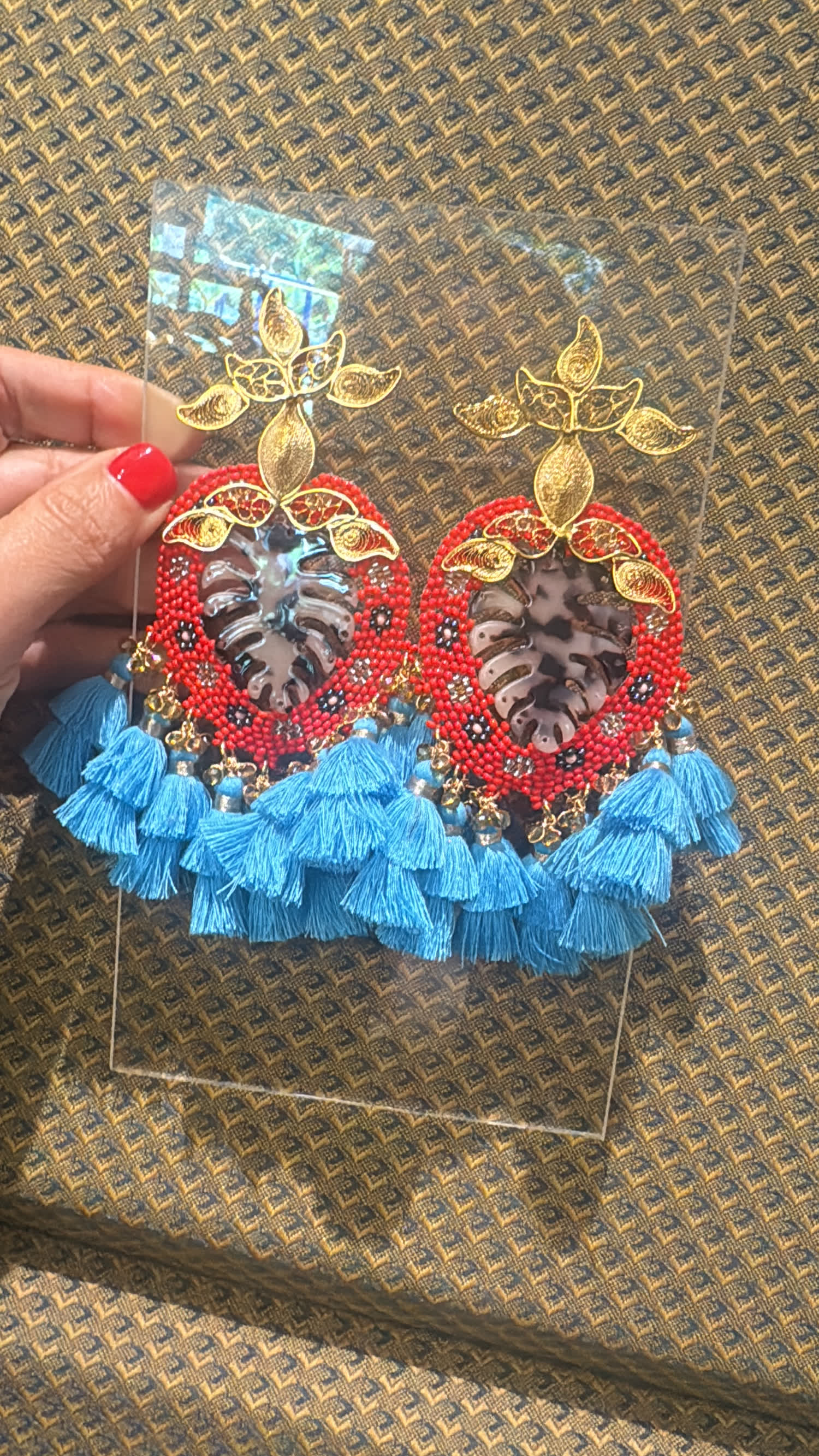 Aretes rojos tejidos con centro de carey y borlas azules