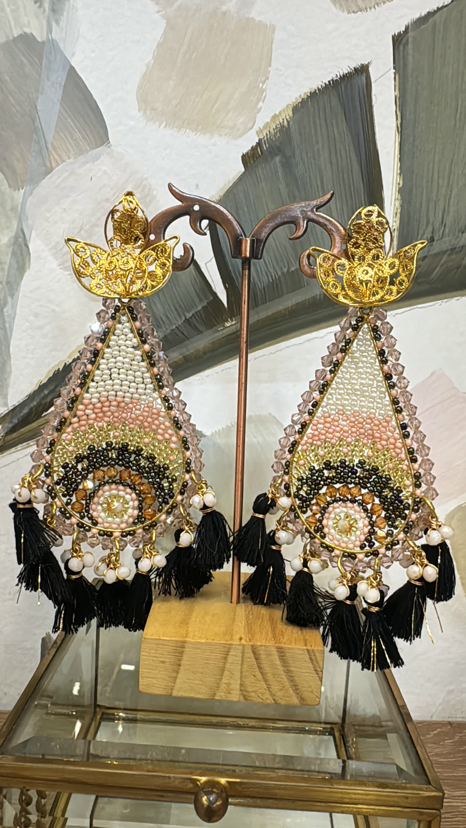 Aretes en gota tejidos en rosa, crema y dorado con borlas negras y perlas