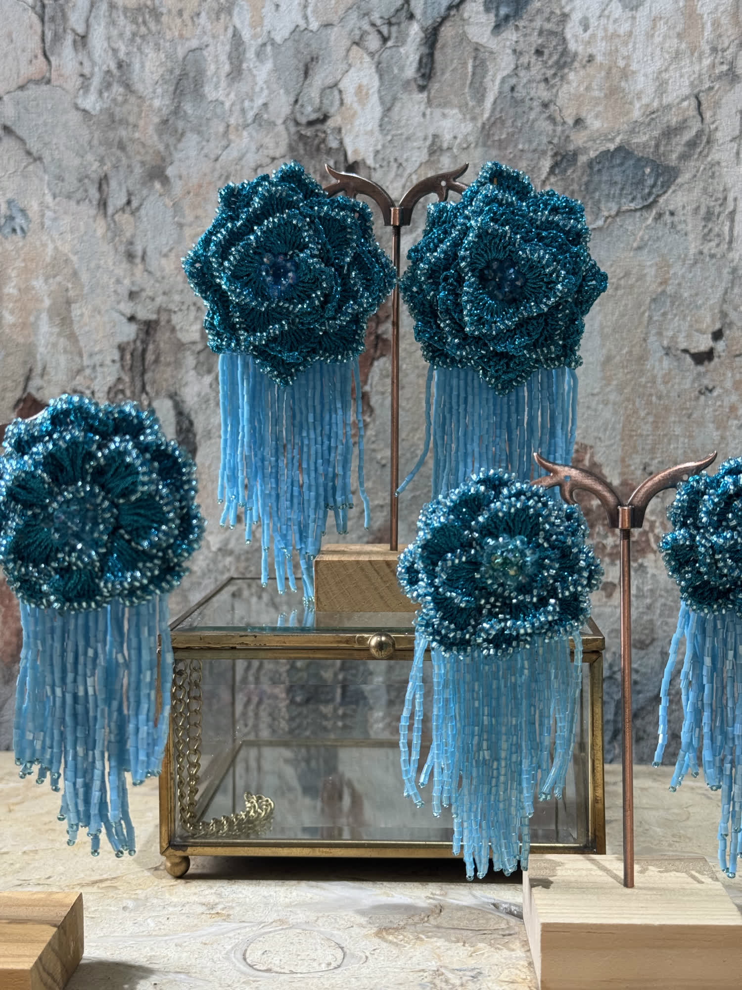 Aretes en forma de rosa tejida en mostacilla azul con flecos