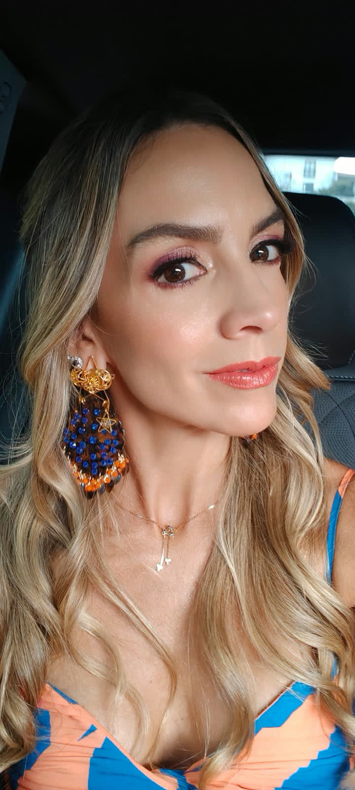 Beatriz Castrillón con aretes tejidos en azul y naranja