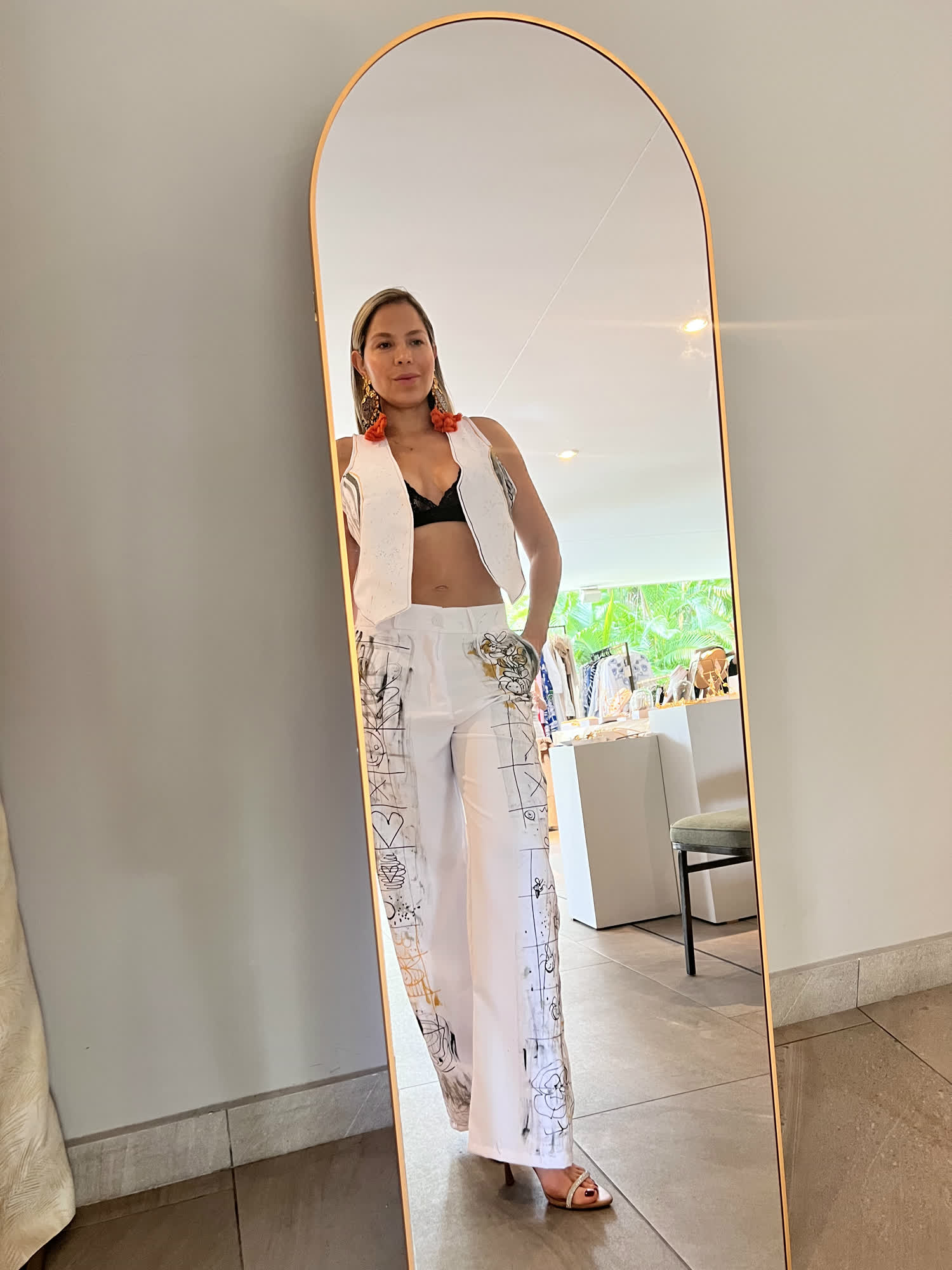 Beatriz Castrillón reflejada en un espejo con un conjunto blanco intervenido