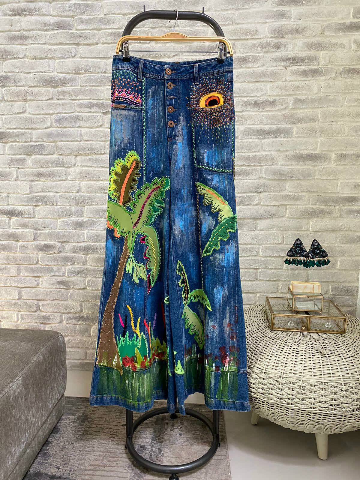 Pantalón acampanado de denim índigo pintado con palmeras y bordado en relieve