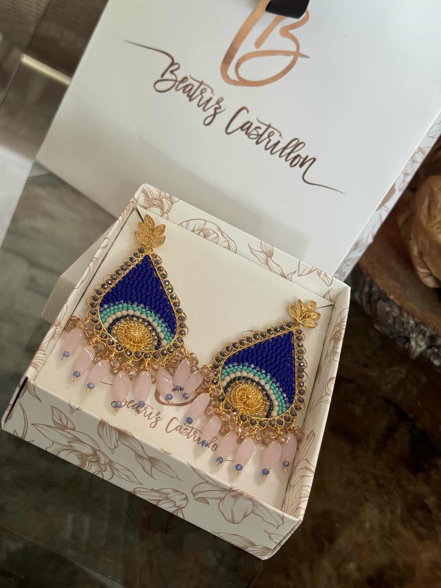 Empaque de la marca Beatriz Castrillón con aretes azules en su interior