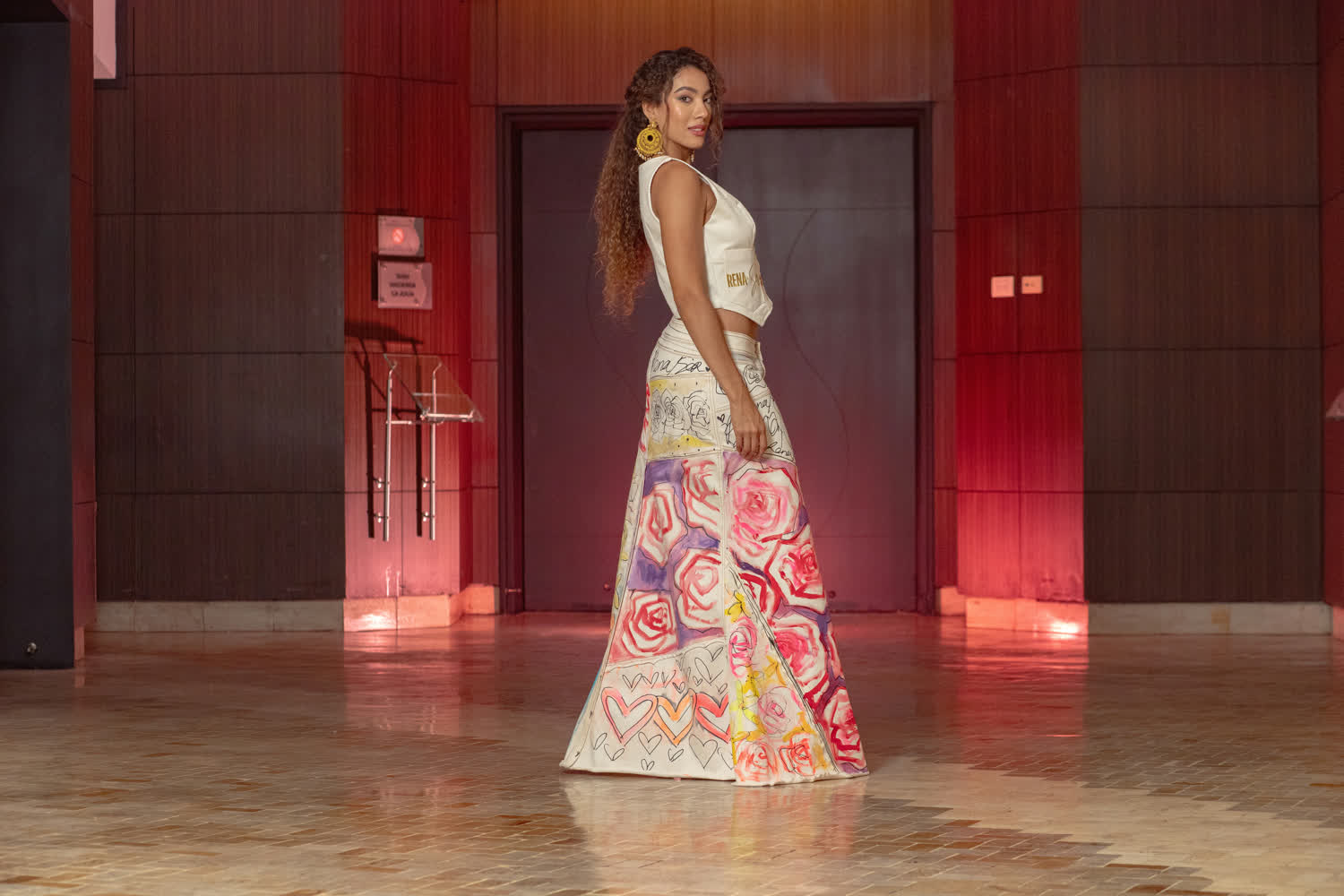 Modelo en pasarela con una falda larga pintada con rosas y corazones