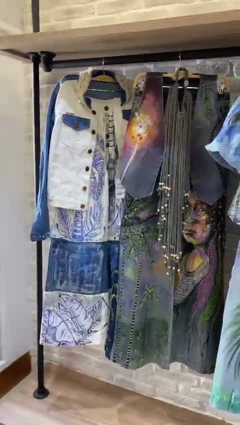 Conjunto de denim pintado con palmeras y vegetación colgado en el taller
